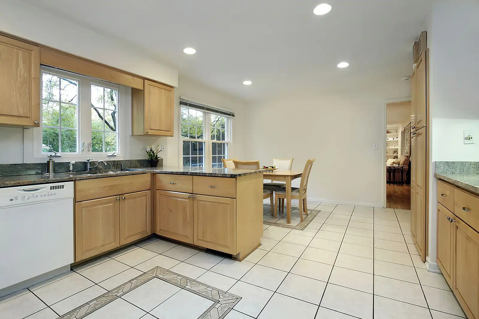 Cream ceramic tile floor in a Justice kitchen with light wood cabinets